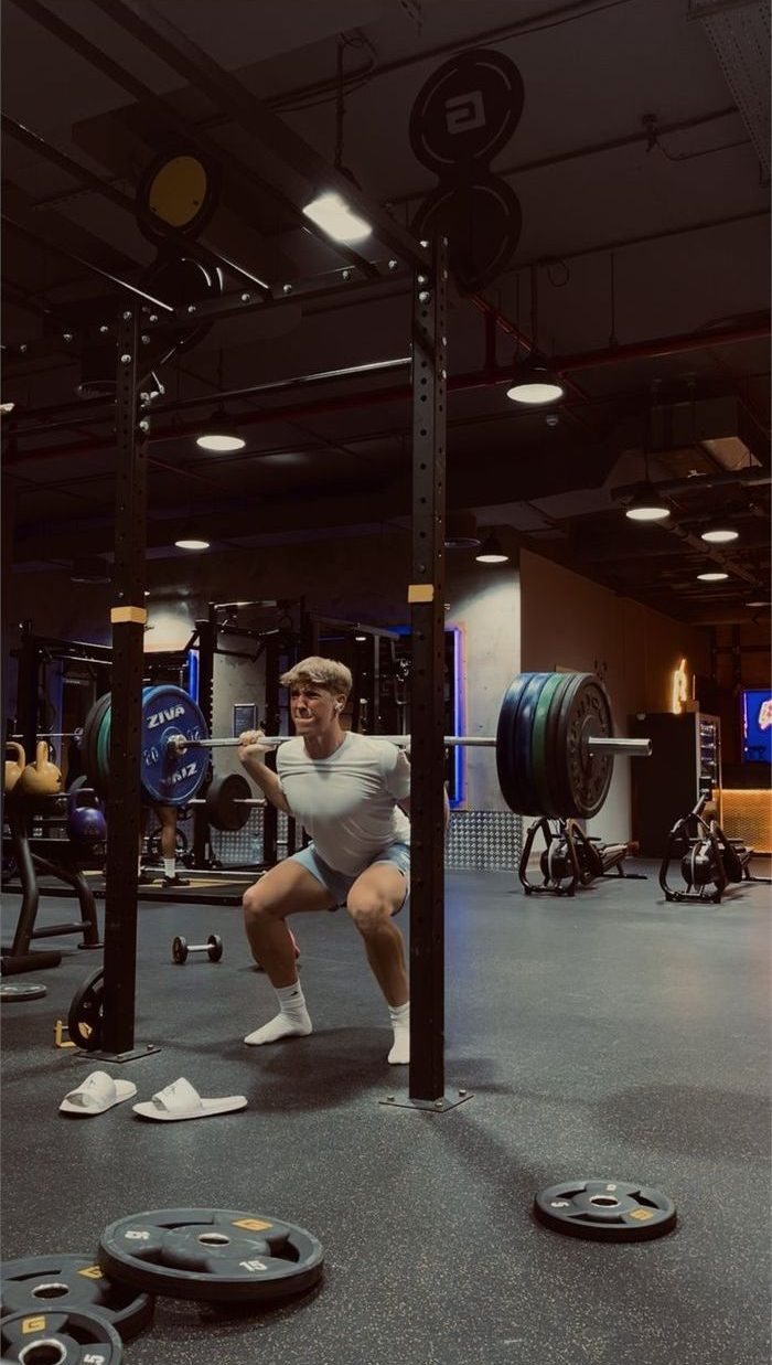 Kallan squatting in a gym